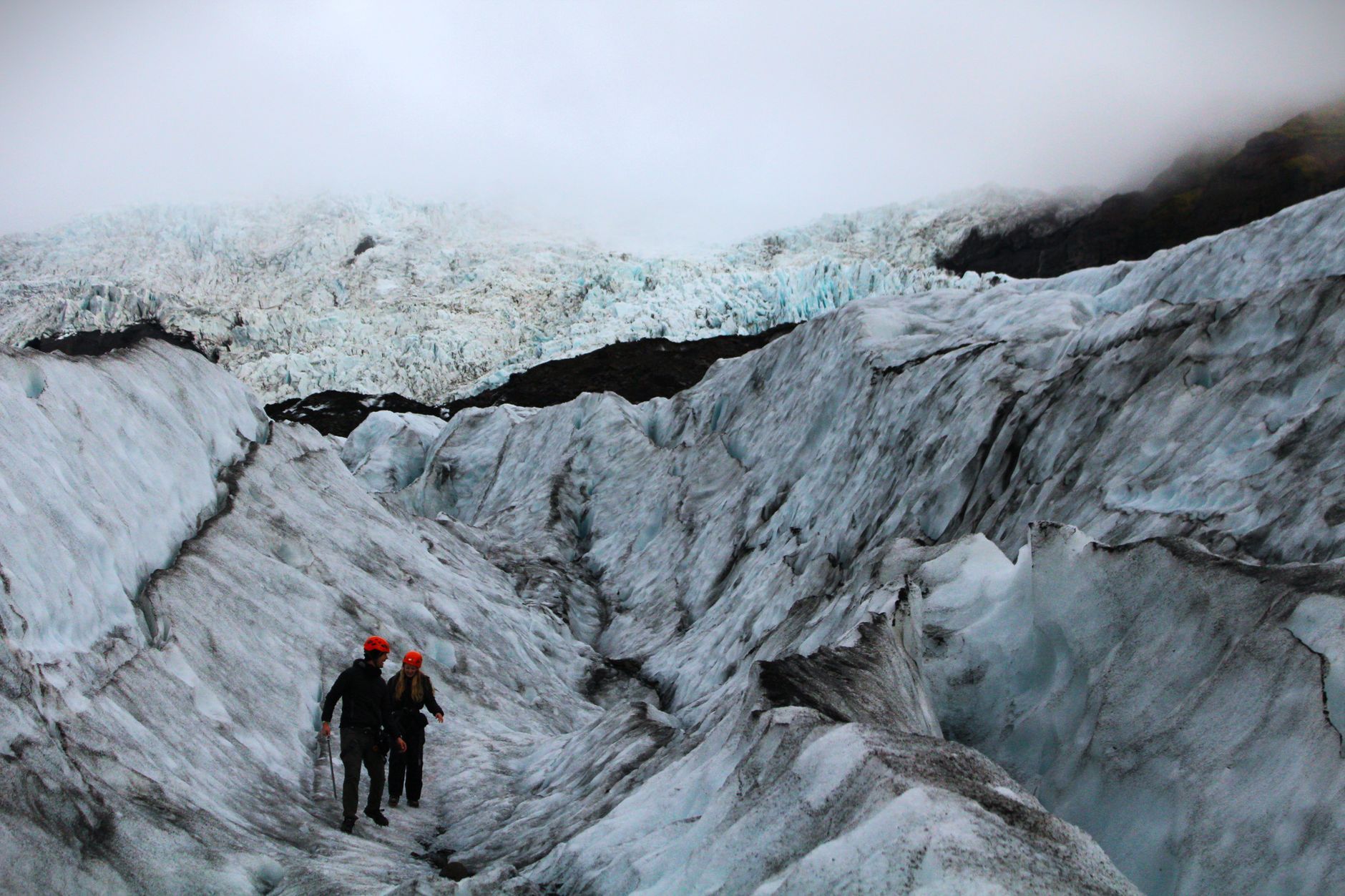 Hiker walking on blue glacier ice in Iceland
