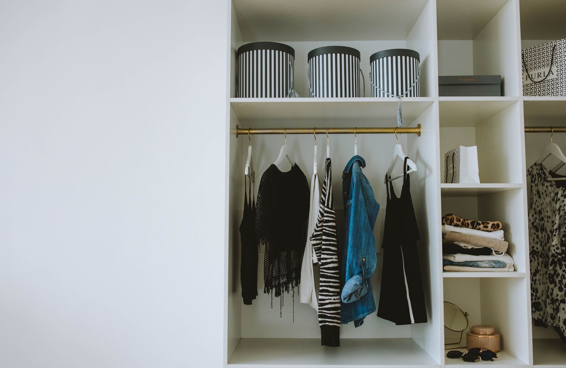 An organized closet with clothes hung neatly and a few labeled storage boxes